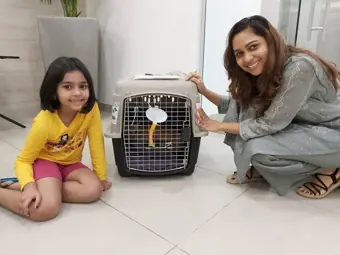 A mother and daughter beside their pet’s travel carrier.